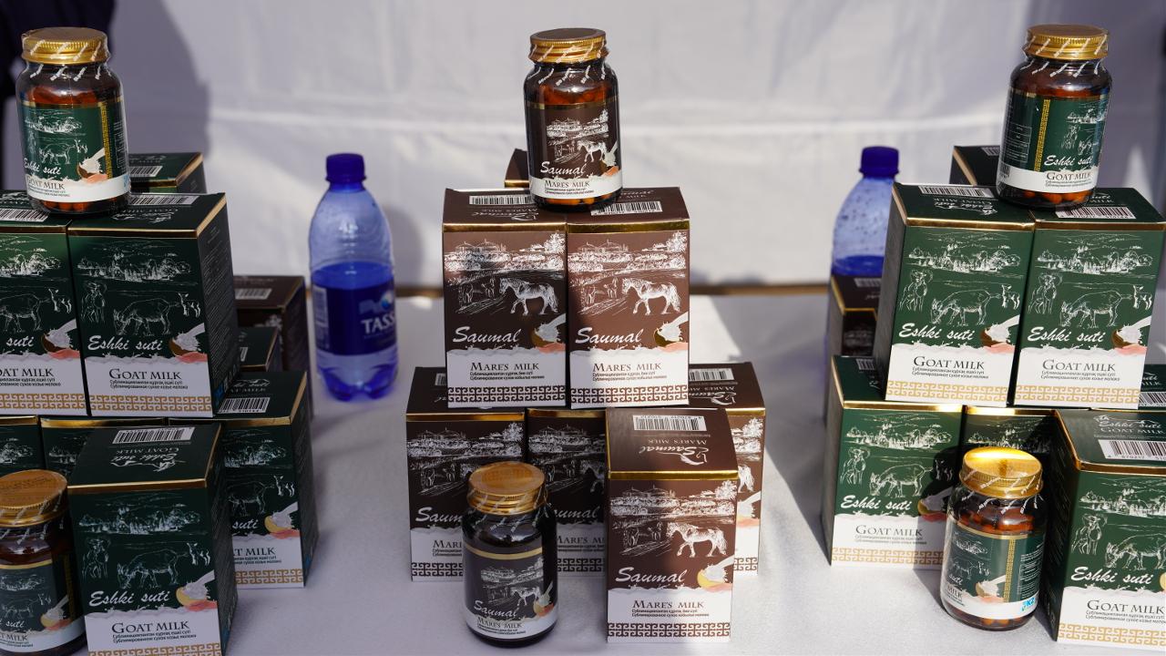 Assorted goat milk product boxes and jars arranged on a table display.